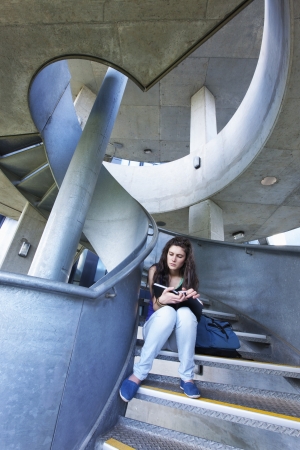 University student reading on staircaseの写真素材