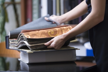 Young designer looks through sample bookの写真素材