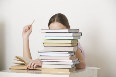 Young woman sits working at booksの写真素材
