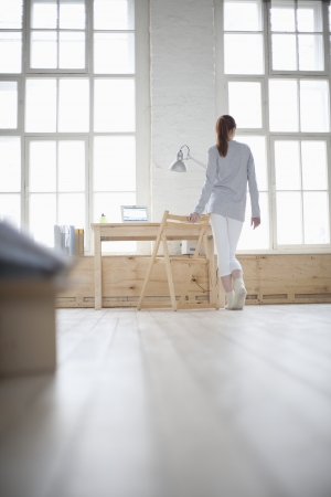 Woman walks across loft apartmentの写真素材