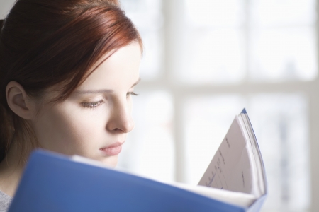 Woman reads blue fileの写真素材