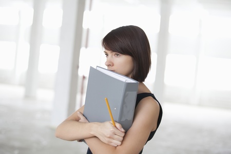 Business woman on holding file in  warehouse interiorの写真素材