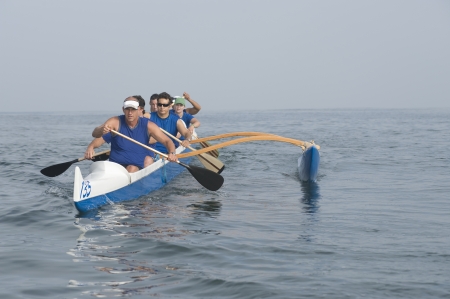 Outrigger canoeing team on waterの写真素材