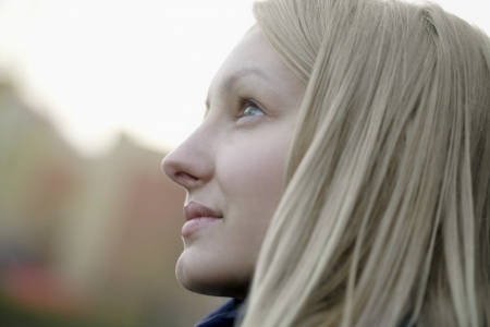Profile of blonde woman outside looking upの写真素材