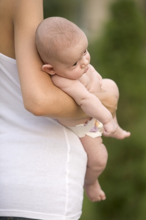 Mother stands holding 2 month old infant sonの写真素材
