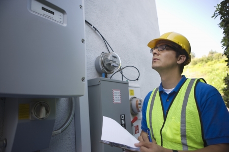 Maintenance worker reads meter of solar generation unit in Los Angeles Californiaの写真素材
