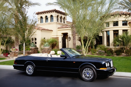 Luxurious convertible car parked in front of a mansion houseの写真素材