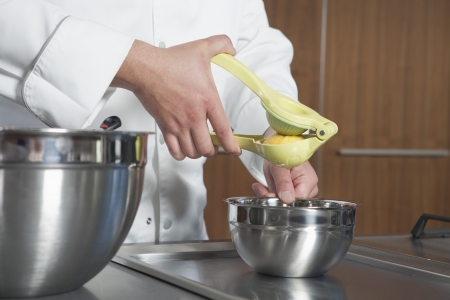 Mid- adult chef squeezing lemonの写真素材