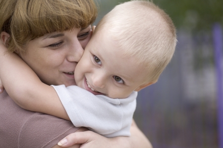 Mother kisses son aged 3-4 yearsの写真素材