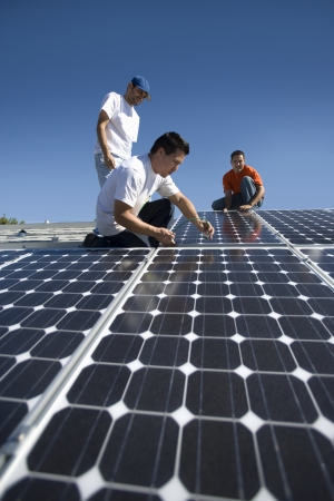A group of men working on solar panellingの写真素材
