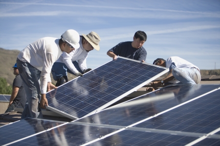 A group of men working on solar panellingの写真素材