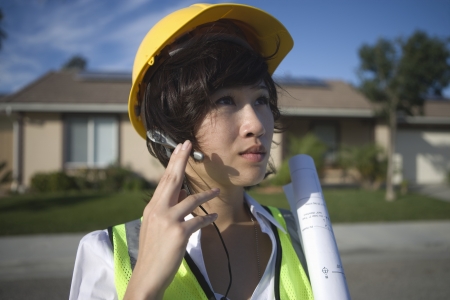A business lady in working uniform with her hand to a mobile device in her earの写真素材