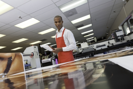 Manual worker looking down at printsの写真素材