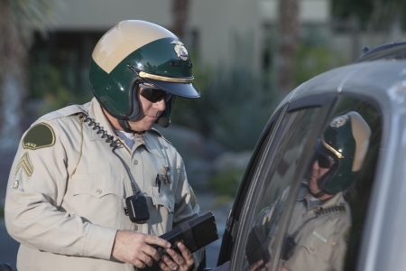 Patrol officer stands at window of luxury car