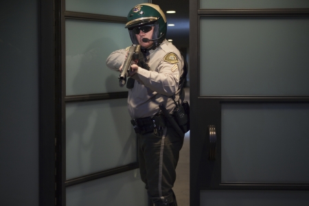 Nightwatch patrolman at doorway with rifle