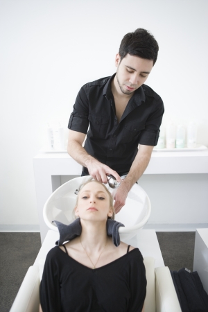 Man washing customers hair in the hairdressersの写真素材