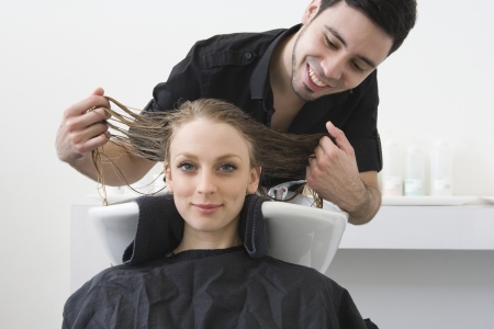 Man washing customers hair in the hairdressersの写真素材