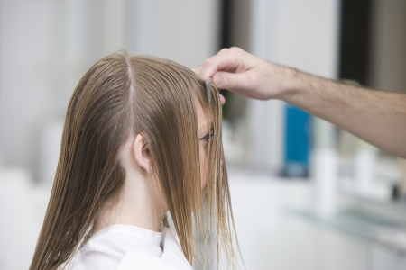 Combing a womans wet hair in the hairdressersの写真素材