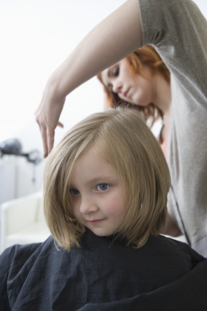A young girl having her hair cut in the hairdressersの写真素材
