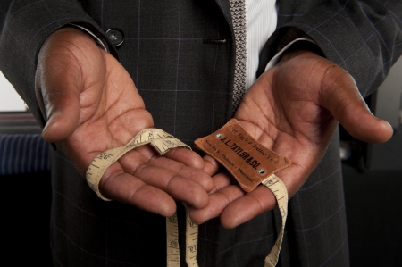 Close-up of hands holding measuring tape and tagの写真素材