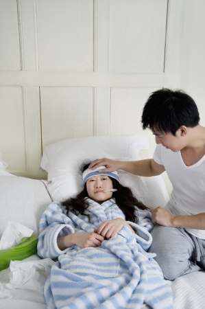 Young man taking care of sick woman in bedの写真素材