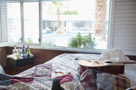 Interior of bedroom with guitar on bed