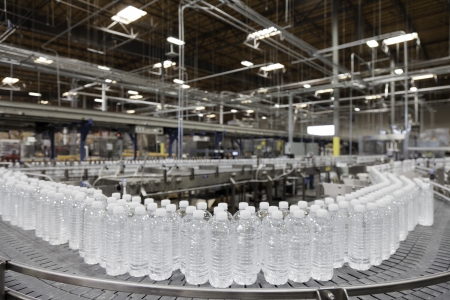 Bottled water on conveyor at bottling plantの写真素材