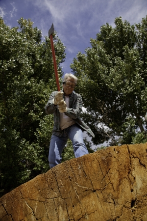 Low angle view of man about to chop woodの写真素材