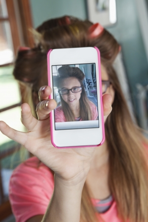 Girl taking self-portrait with cell phoneの写真素材