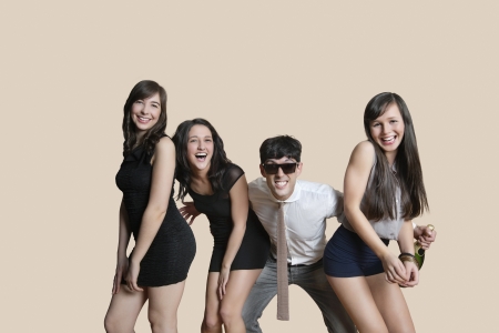 Portrait of cheerful young friends posing over colored backgroundの写真素材