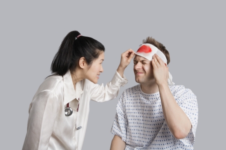 Patient suffering from pain while doctor examining himの写真素材