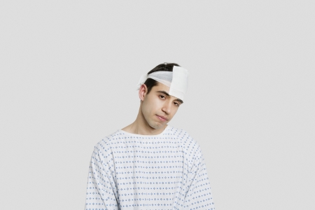 Sad male patient with bandage on headの写真素材