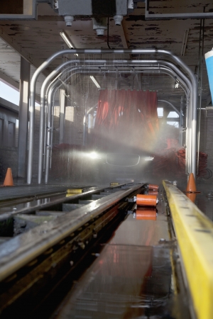 Motor vehicle going through a cleaning process in car washの写真素材