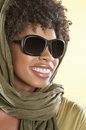 Happy African American wearing sunglasses with stole over her headの写真素材