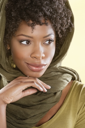 Beautiful African American woman looking away over colored backgroundの写真素材