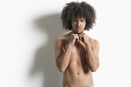 Portrait of young man with fist standing over white backgroundの写真素材