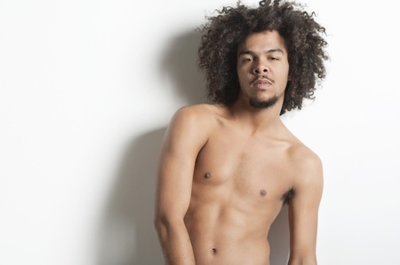 Portrait of a shirtless young man over white backgroundの写真素材