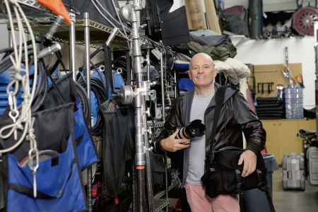 Portrait of a happy senior photographer in studio