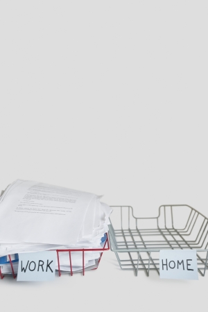 Pile of papers in work tray with empty home platter over white backgroundの写真素材