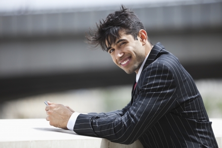 Portrait of smiling Indian businessman in pinstriped suit outdoorsの写真素材