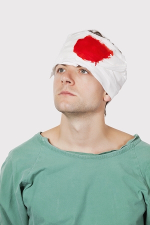 pensive young male patient with serious head injury against gray backgroundの写真素材