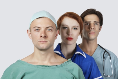 Portrait of three confident medical practitioners against gray backgroundの写真素材