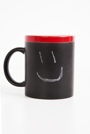 Close-up of smiley drawn on cup over white backgroundの写真素材