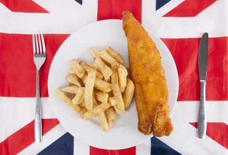 Close-up of junk food with fork and table knife over British flagの写真素材