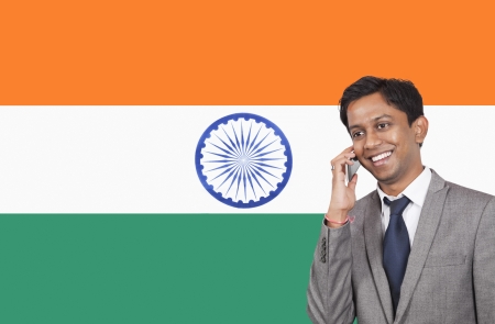 Young businessman using cell phone over Indian flagの写真素材
