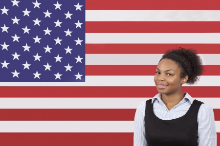 Young African American businesswoman smiling over American flagの写真素材
