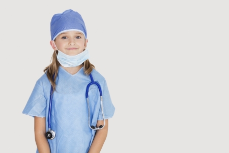 Portrait of young girl in surgeon's costume against gray backgroundの写真素材