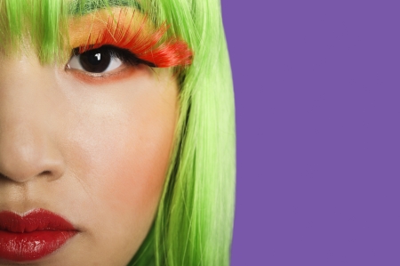 Cropped image of young woman wearing false eyelashes against purple backgroundの写真素材