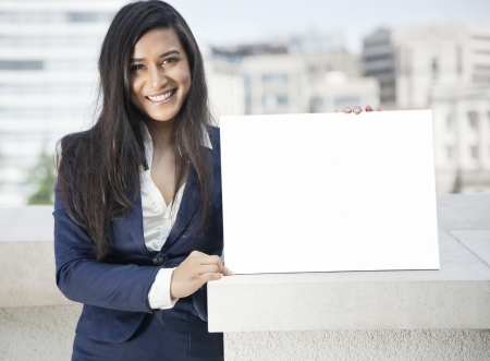 Portrait of a young Indian businesswoman holding Moodboard signの写真素材