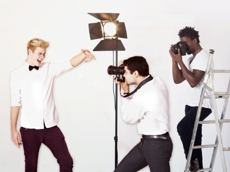 Paparazzi taking photographs of male actor over white backgroundの写真素材